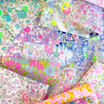 Curated scrap bags containing an assortment of bright neon Liberty Tana Lawn pieces, ranging in sizes from 6-25cm in diameter (2.5"-10").