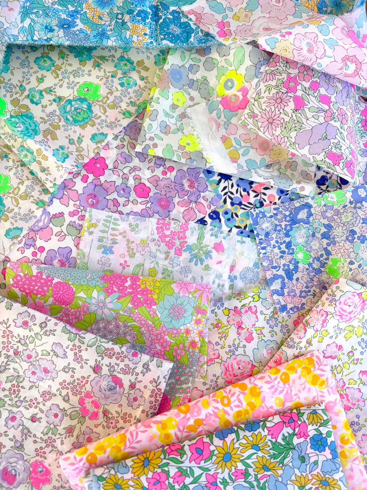 Curated scrap bags containing an assortment of bright neon Liberty Tana Lawn pieces, ranging in sizes from 6-25cm in diameter (2.5"-10").