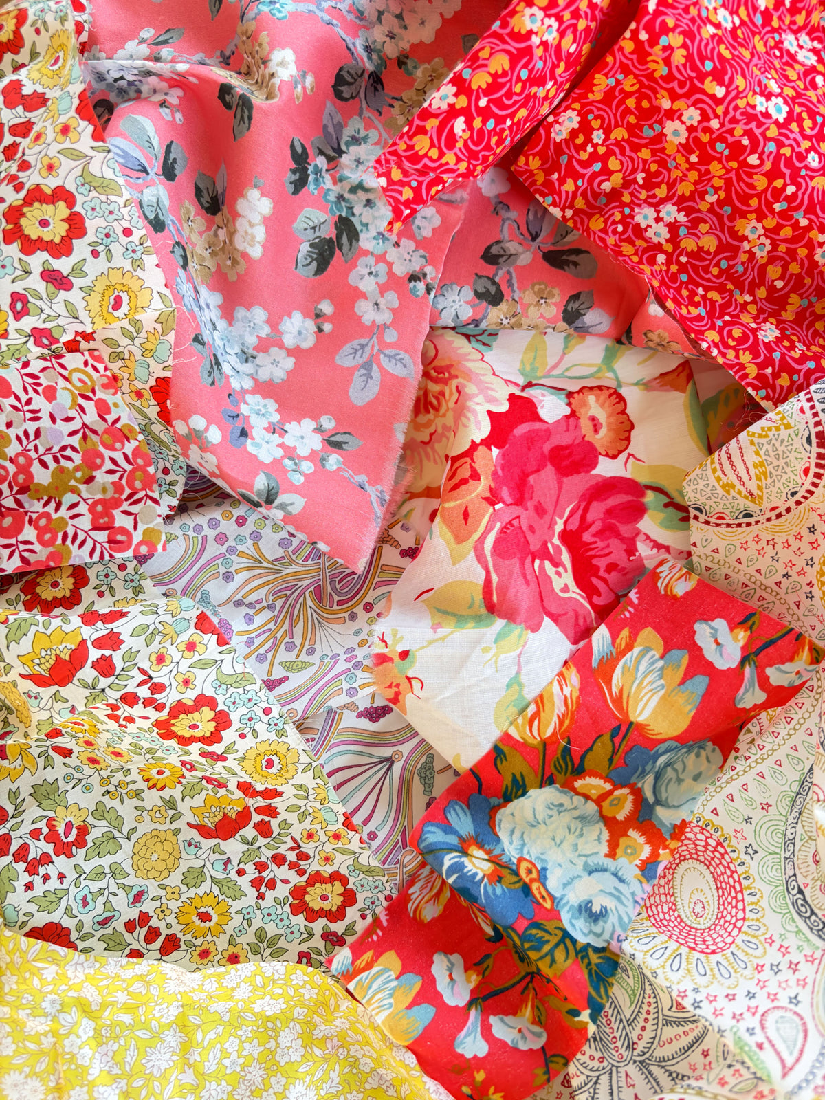 A curated scrap bag containing an assortment of Liberty Tana Lawn pieces, ranging in sizes from 6-25cm in diameter (2.5"-10"). Painted Desert is a collection of Tana Lawn prints inspired by the Australian outback - vibrant reds, mustards, and golds.