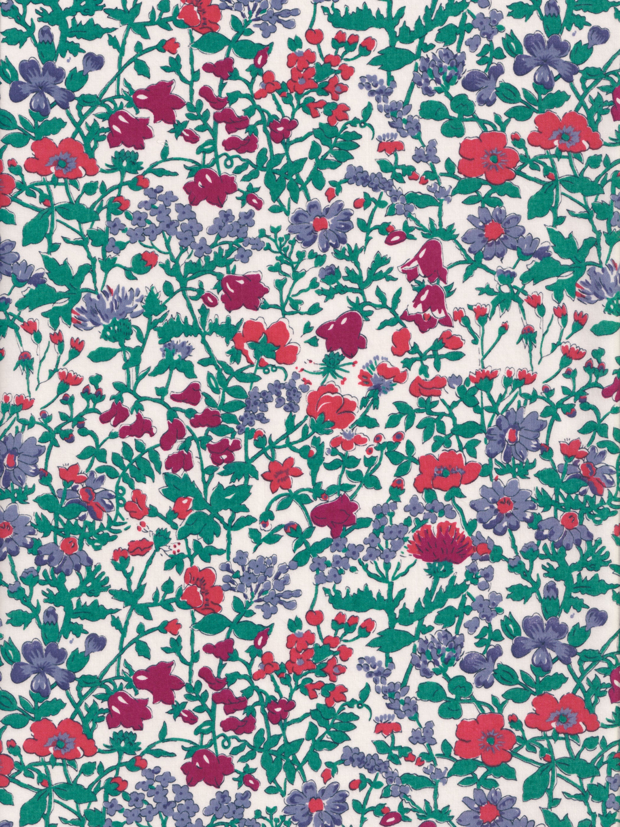 A rare vintage Clover floral Liberty print from the 1980s, with a sweet wildflower print in shades of blue, red, and deep green on a warm white background.