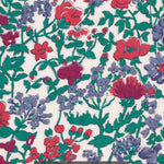 A rare vintage Clover floral Liberty print from the 1980s, with a sweet wildflower print in shades of blue, red, and deep green on a warm white background.